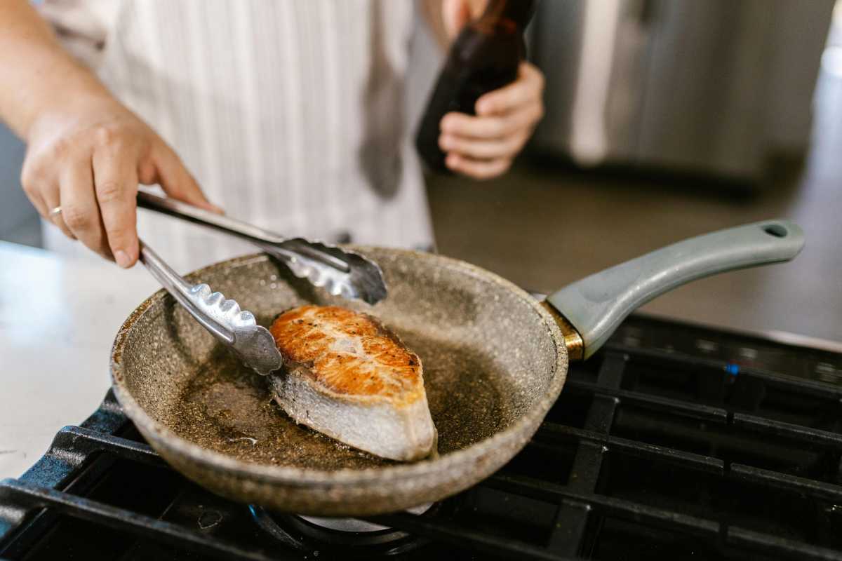 donna che cucina con padella antiaderente