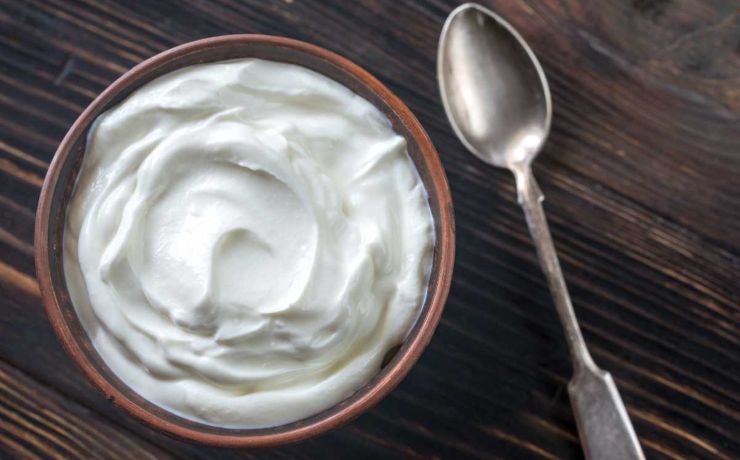 yogurt bianco in ciotola con cucchiaino