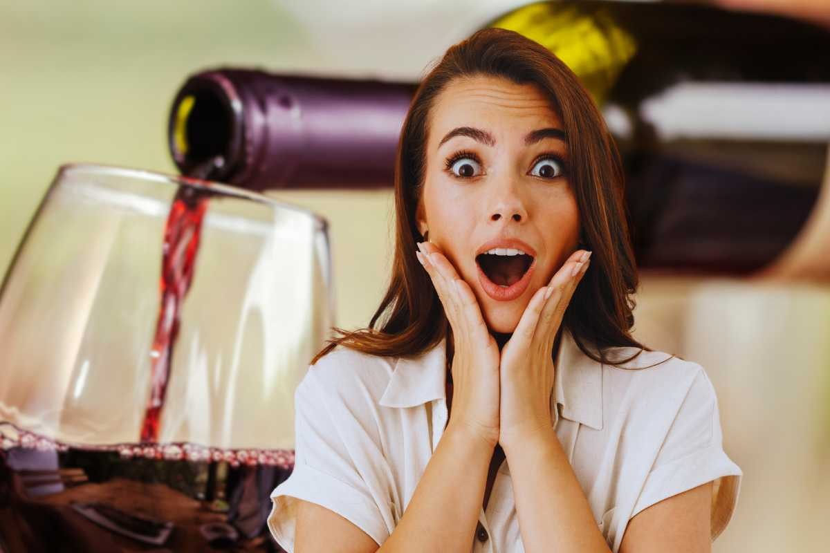 donna sorpresa e calice di vino con bottiglia